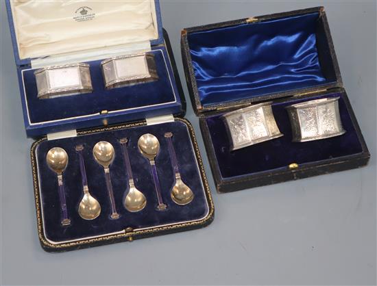 A cased set of six George V silver and enamel coffee spoons and two cased pairs of silver napkin rings, including Victorian.